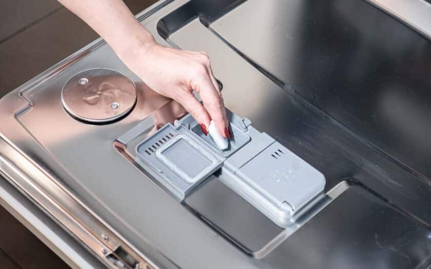 Kvinne putter Sun oppvasktablett i oppvaskmaskinen.